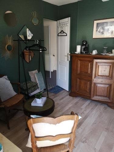 Chambre aux murs vert foncé avec mobilier de bois