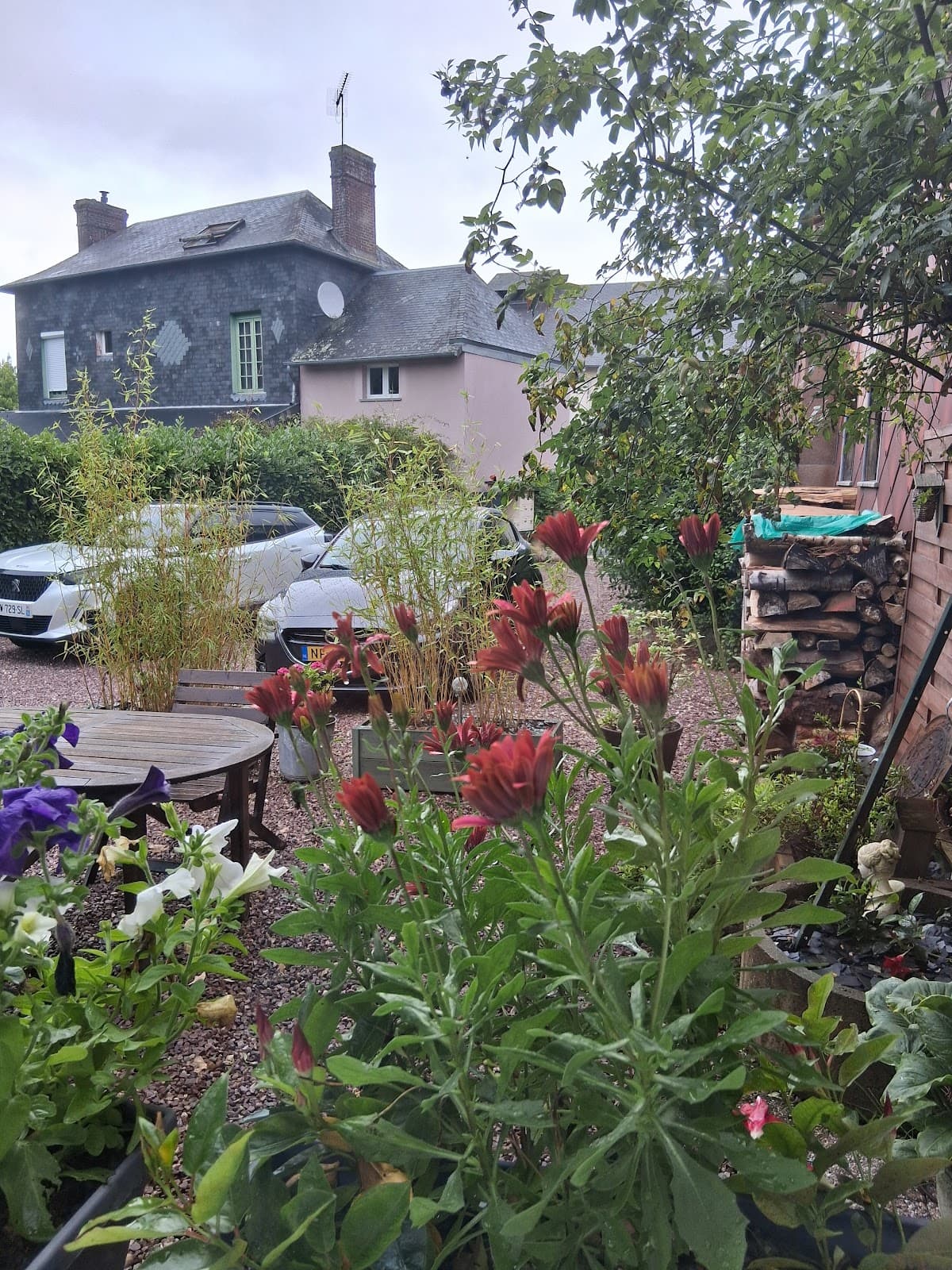 La façade de la propriété et son jardin fleuri, vue depuis la rue