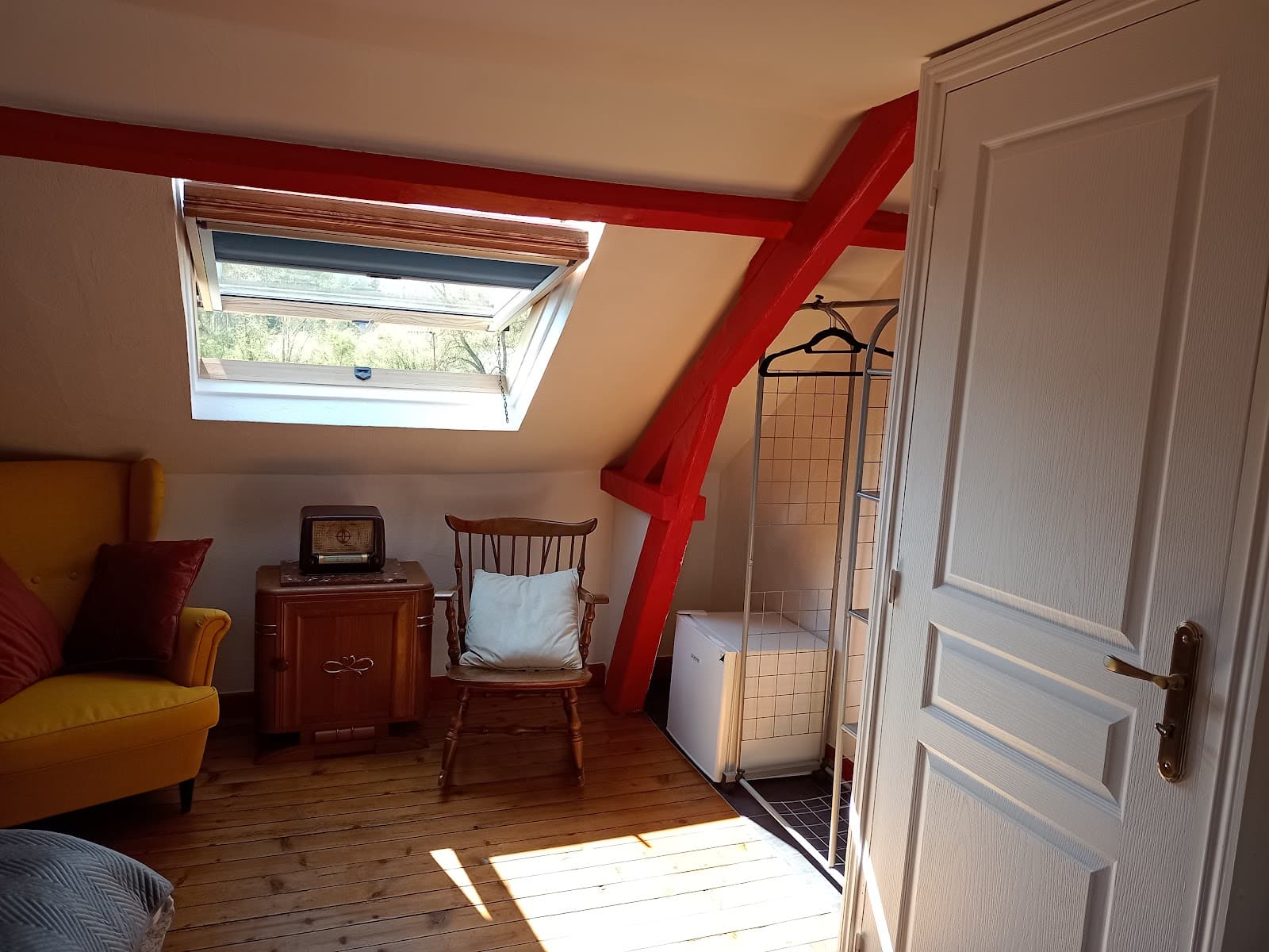 Coin salon de la suite mansardée, porte de la salle de bain ouverte